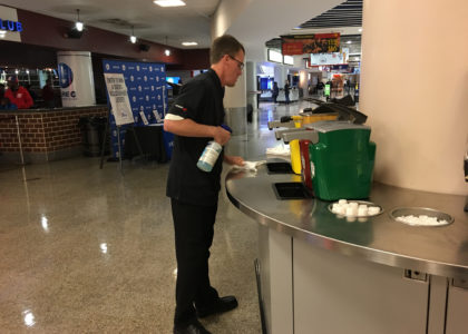 Concessions worker wiping counters